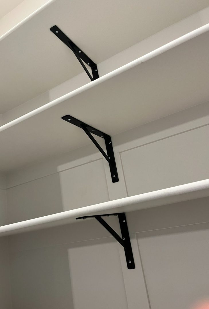 Knape & Vogt black shelf brackets installed in an Anthem Pacific show home, adding sturdy support and a modern industrial look to open shelving, perfectly complementing the contemporary style of the space.