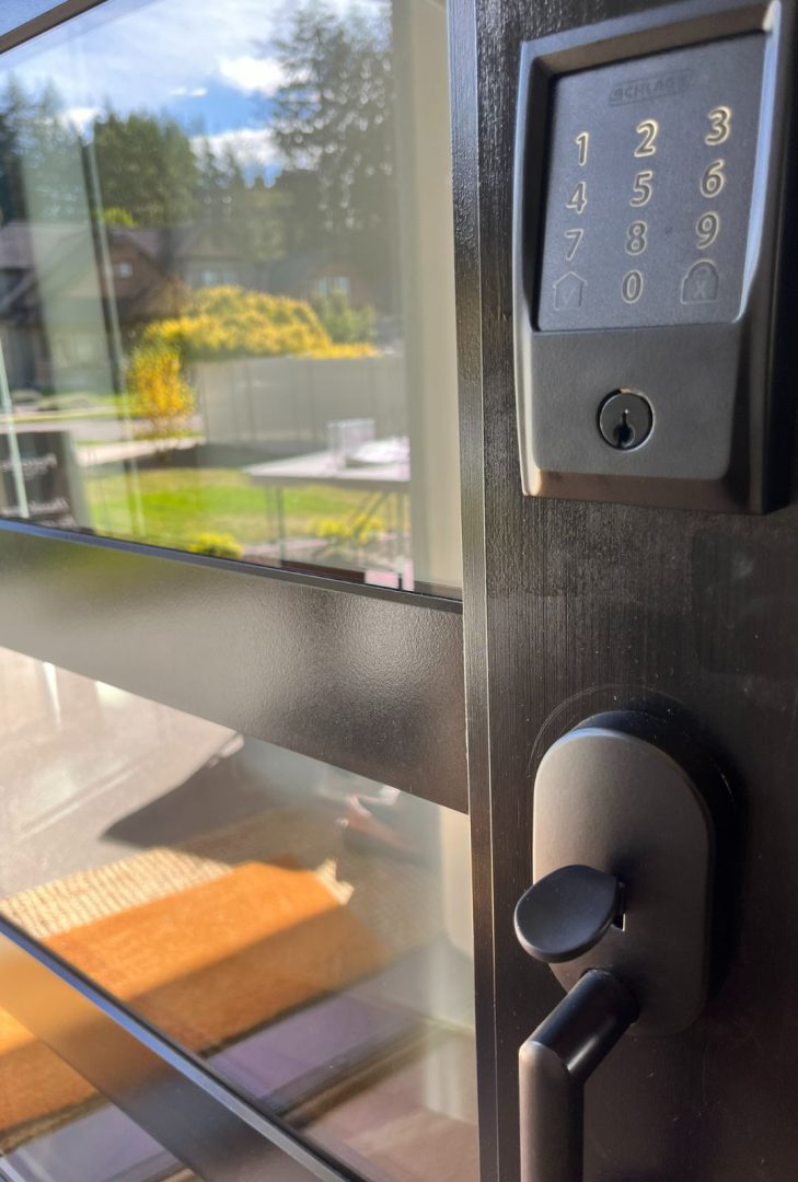 Schlage Encode Smart WiFi Deadbolt in a matte black finish, installed on an exterior door, offering keyless entry and enhanced security with built-in WiFi for remote access and control via smartphone. Anthem Pacific Builders, 2024 NIBCA Parade of Homes.