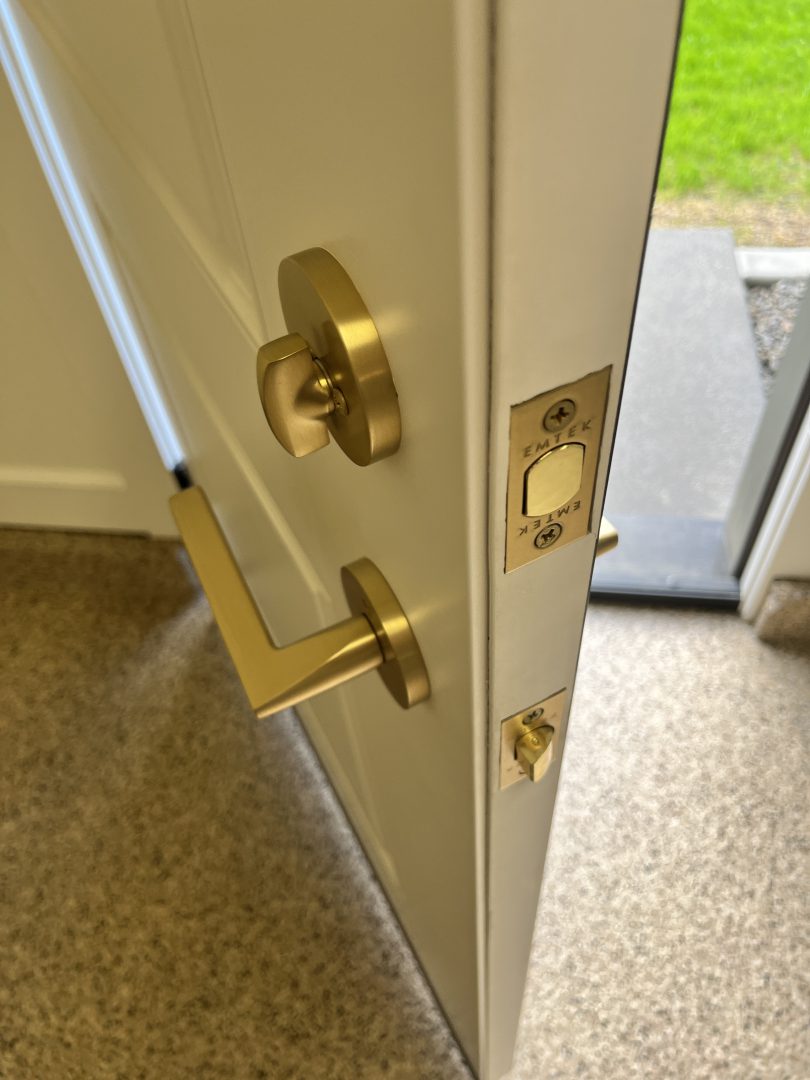 Emtek Modern Helios Door Leverset with Disk Rosette in a satin brass finish, installed on an interior door. The sleek lever design and round rosette add a modern, minimalist touch, making it a perfect choice for contemporary homes.