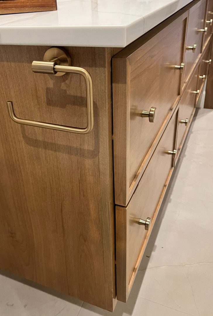 Amerock Arrondi bathroom hardware collection in a stunning golden champagne finish, featured in a Monarch Homes build. The collection includes towel bars, robe hooks, and drawer pulls, adding a warm, luxurious touch to the bathroom space while perfectly complementing modern and elegant design elements.