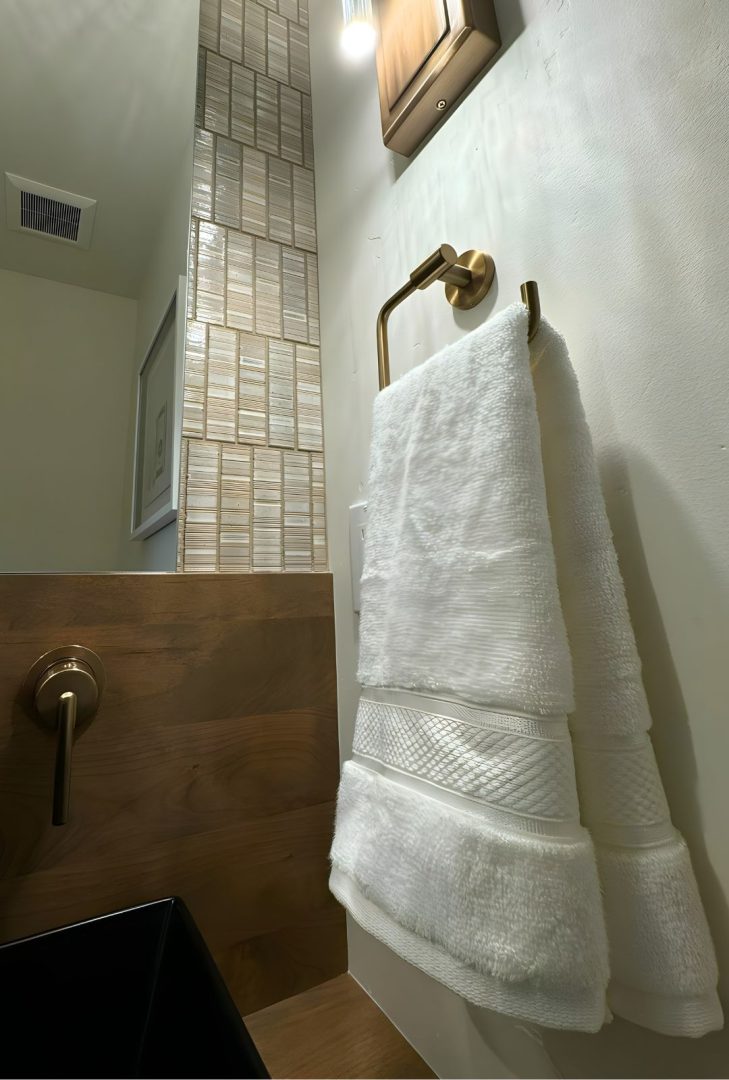 Amerock Arrondi bathroom hardware collection in a stunning golden champagne finish, featured in a Monarch Homes build. The collection includes towel bars, robe hooks, and drawer pulls, adding a warm, luxurious touch to the bathroom space while perfectly complementing modern and elegant design elements.