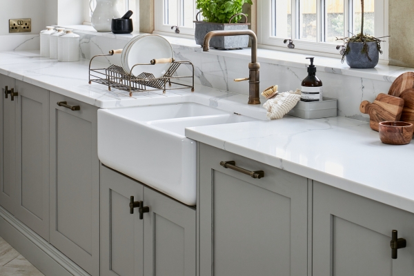 Luxury kitchen featuring Armac Martin solid brass cabinet knobs and pulls on custom gray cabinetry with coordinated brass fixtures.
